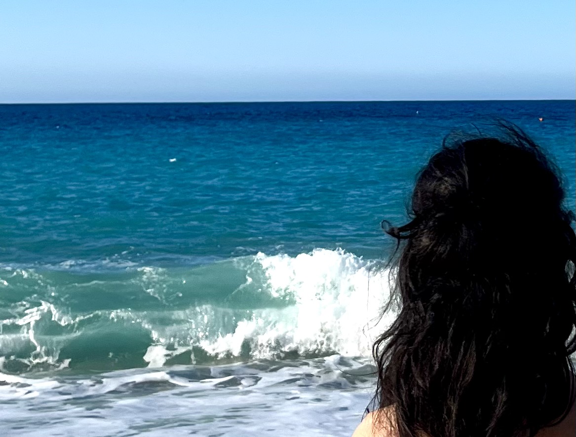 L'autrice della poesia Beatrice Condorelli, di spalle mentre guarda il mare