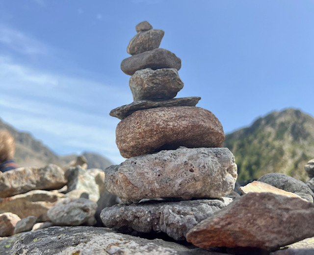 Una serie di sassi impilati dal più grande al più piccolo all'interno di un paesaggio di montagna